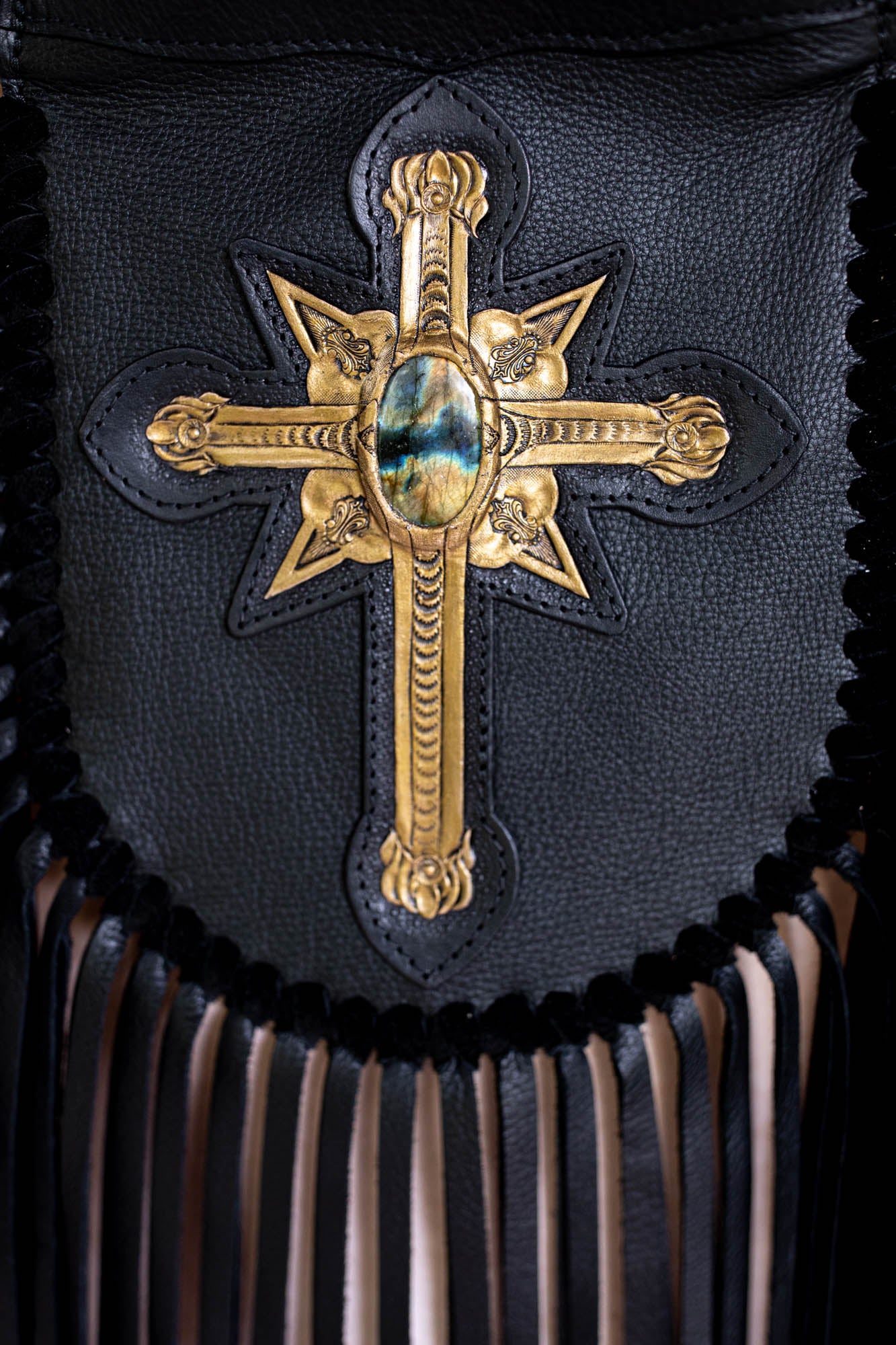 Black leather bag with a gold cross emblem
