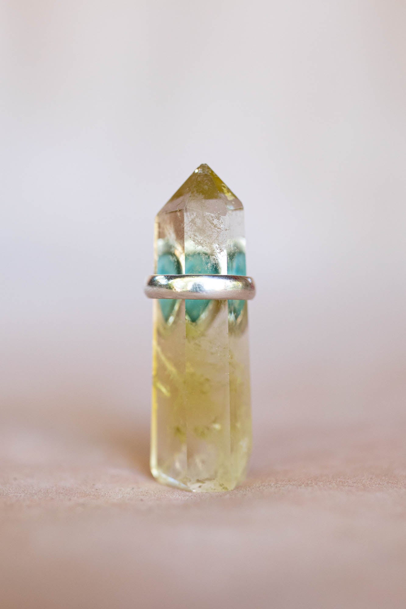 Clear crystal with a silver base on a light pink background
